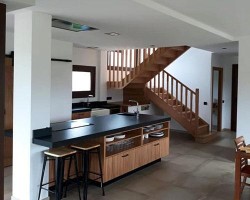 foto entrada y cocina de vivienda reformada en tonos madera