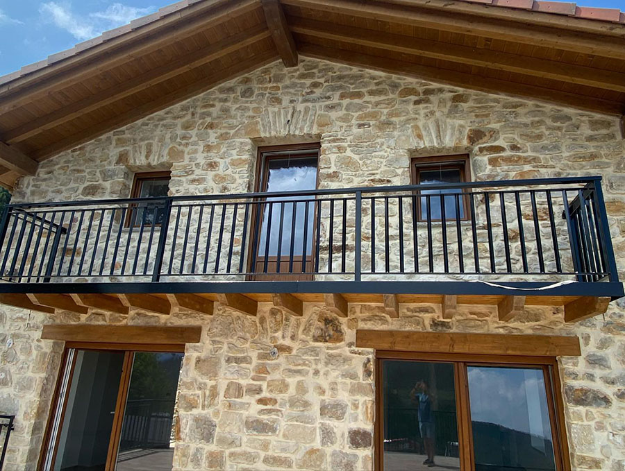 fachada edificación de piedras y tejado con estructura de madera