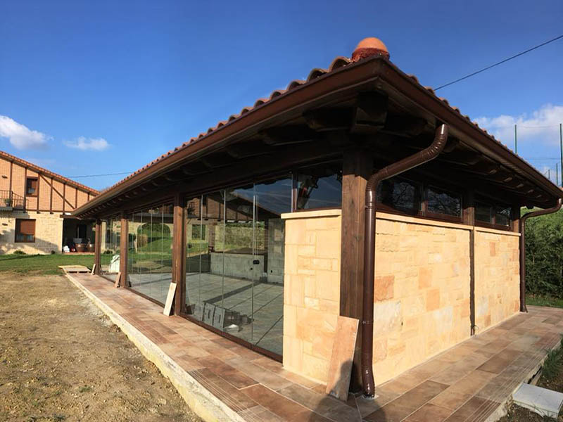 cenador exterior cubierto acristalada y con estructura de madera
